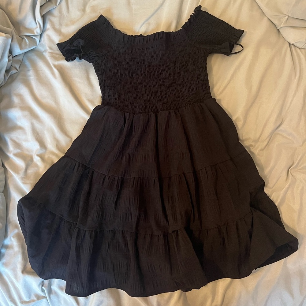 black flowy dress with short puff sleeves and an elastic chest area